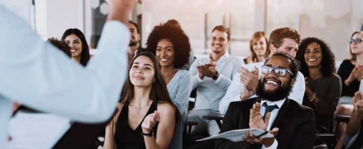 teammates smile and clap during an event